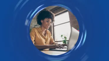 Persona trabajando en una laptop junto a una ventana.