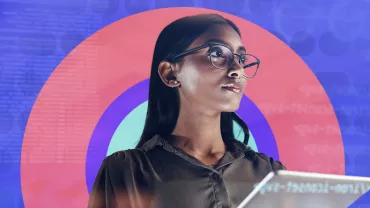 Persona con gafas sosteniendo una tableta frente a un fondo colorido de círculos y texto.