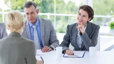 Profesionales senior en entrevista de trabajo para atraer talento gracias a políticas transparentes. 