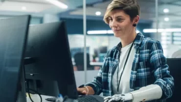 Mujer con una prótesis en el brazo trabajando en una oficina