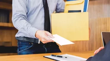 Hombre dando una carta de renuncia voluntaria a su jefe
