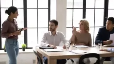 Equipo de trabajo satisfecho trabajando en un entorno de oficina colaborativo.