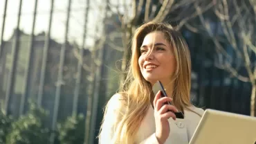 Chica con el teléfono movil vestida de forma profesional