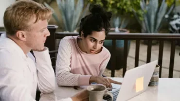 Dos personas mirando la pantalla del ordenador de forma interesada