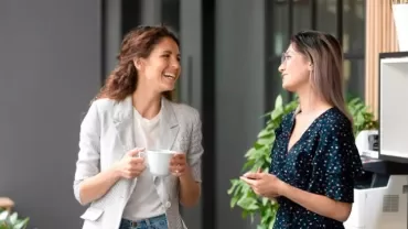 dos mujeres hablando y sonriendo con mucha inteligencia emocional