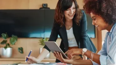 dos mujeres sonrientes tras escribir revisar las plantillas de seguimiento