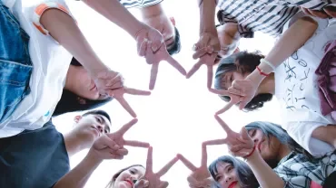 grupo de trabajo creando una estrella con los dedos de cada uno
