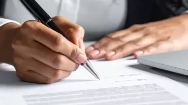 detalle de la mano de una persona firmando un contrato