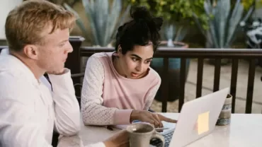mujer y hombre mirando en la pantalla del ordenador sorprendidos