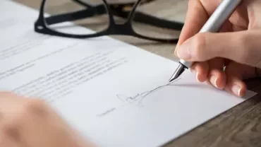 mano firmando un contrato con una pluma