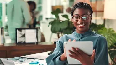 Una manager sonriente que revisa su tableta