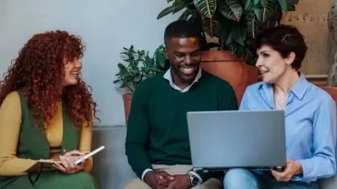 compañeros de trabajo comentando una presentación en una oficina moderna