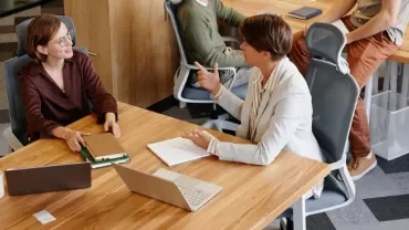 profesionales hablando sobre una subida de sueldo en una oficina moderna