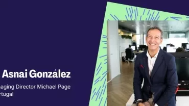Retrato corporativo de un líder sentado en una oficina moderna de fondo.
