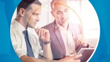 Dos personas en una oficina revisando una tablet.