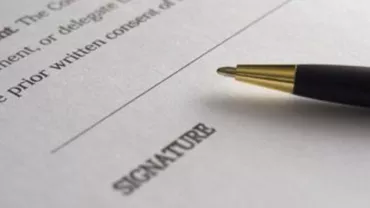 Un bolígrafo sobre un contrato con espacio para la firma.