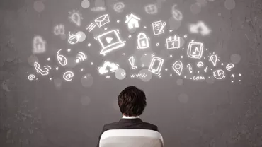 Persona mirando iconos digitales que flotan sobre un fondo gris.