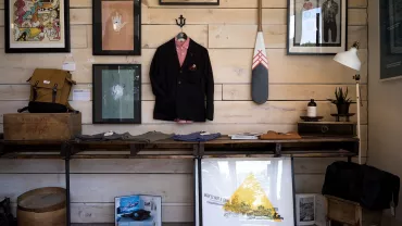 Exhibición en una tienda con ropa, arte y decoraciones.