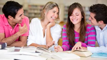 Grupo de personas estudiando y sonriendo en una biblioteca