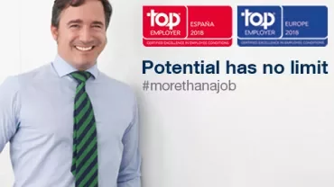 Persona sonriendo junto a premios de Top Employer España y Europa 2018.