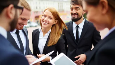 Grupo de profesionales sonrientes al aire libre.