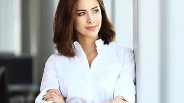 Persona sonriendo con una camisa blanca.