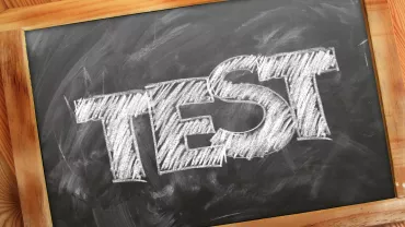 La palabra 'TEST' escrita en una pizarra con tiza blanca.