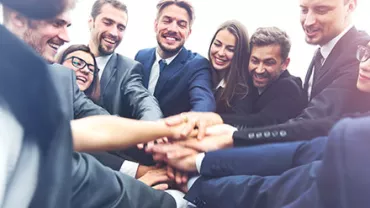 Grupo de personas uniendo sus manos en señal de trabajo en equipo.