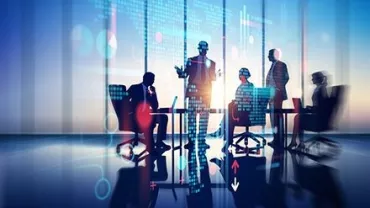 Personas en una reunión con gráficos virtuales en la pantalla.