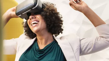 Persona usando un visor VR con expresión alegre.