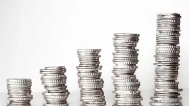 Varias pilas de monedas plateadas apiladas en aumento.