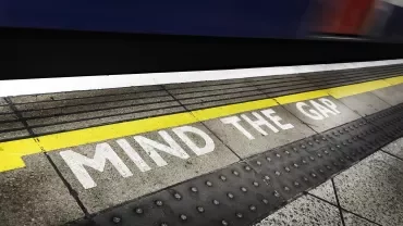 Texto en el suelo de una estación de metro: 'Mind the Gap'