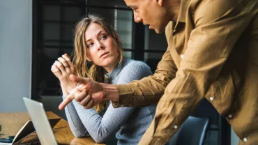 Dos personas discutiendo un tema en la oficina.