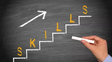 La palabra 'skills' en una escalera de tiza con flecha ascendente.