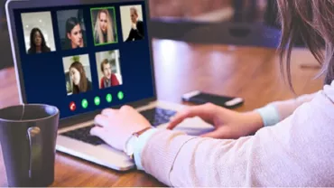 Persona usando una laptop para una videollamada con seis participantes.