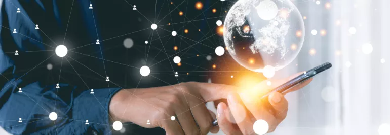 Persona usando un teléfono móvil con un holograma del mundo y conexiones de red.