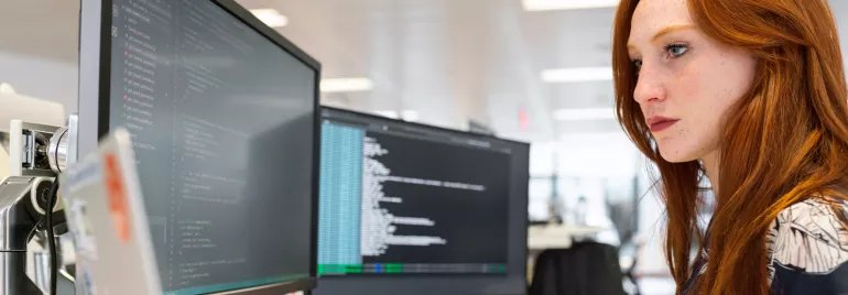 Persona trabajando en una computadora en una oficina moderna.