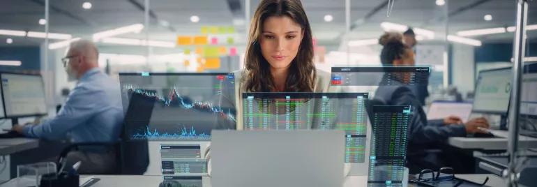 Mujer sentada delante del ordenador portátil mientras trabaja en analítica de datos