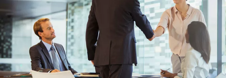 Reunión de negocios con personas dando la mano en la oficina.