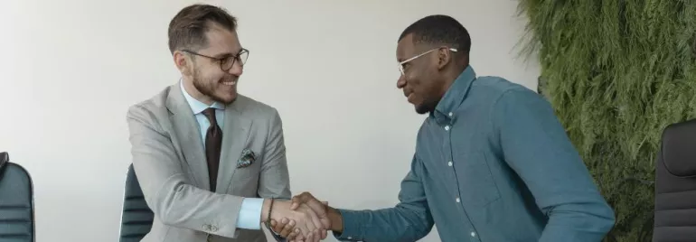 Dos hombres dándose la mano en una entrevista