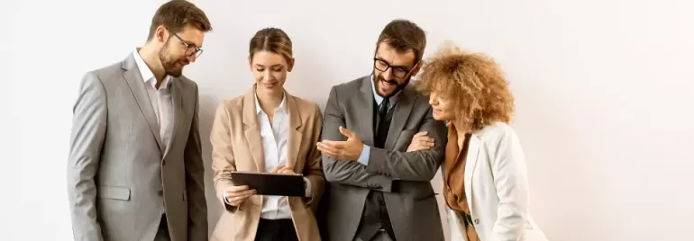 equipo de personas de oficina mirando una tablet y comentando entre ellos