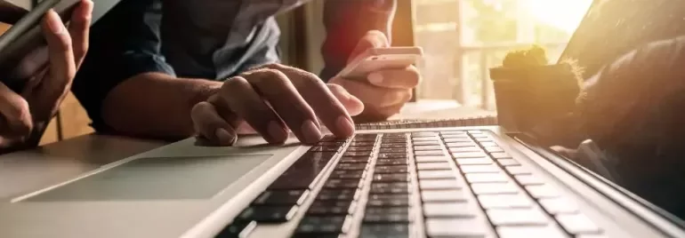 Teclado de ordenador con manos haciendo click en teclas