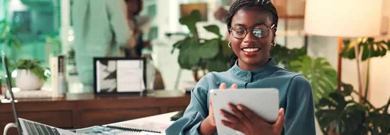 Una manager sonriente que revisa su tableta