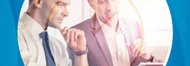 Dos personas en una oficina revisando una tablet.