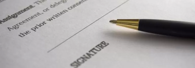 Un bolígrafo sobre un contrato con espacio para la firma.