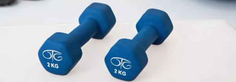 Par de mancuernas azules de 2 kg cada una sobre una superficie blanca.