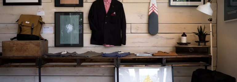 Exhibición en una tienda con ropa, arte y decoraciones.