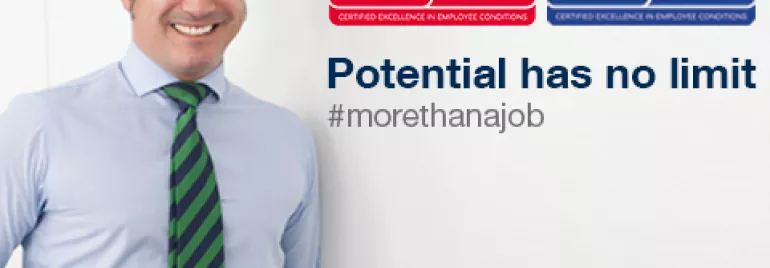 Persona sonriendo junto a premios de Top Employer España y Europa 2018.