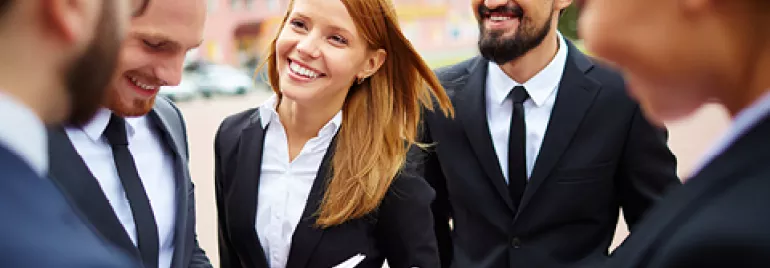 Grupo de profesionales sonrientes al aire libre.