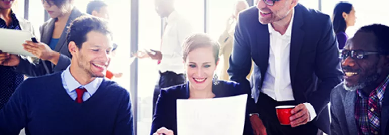 Grupo de personas trabajando en equipo en una oficina moderna.